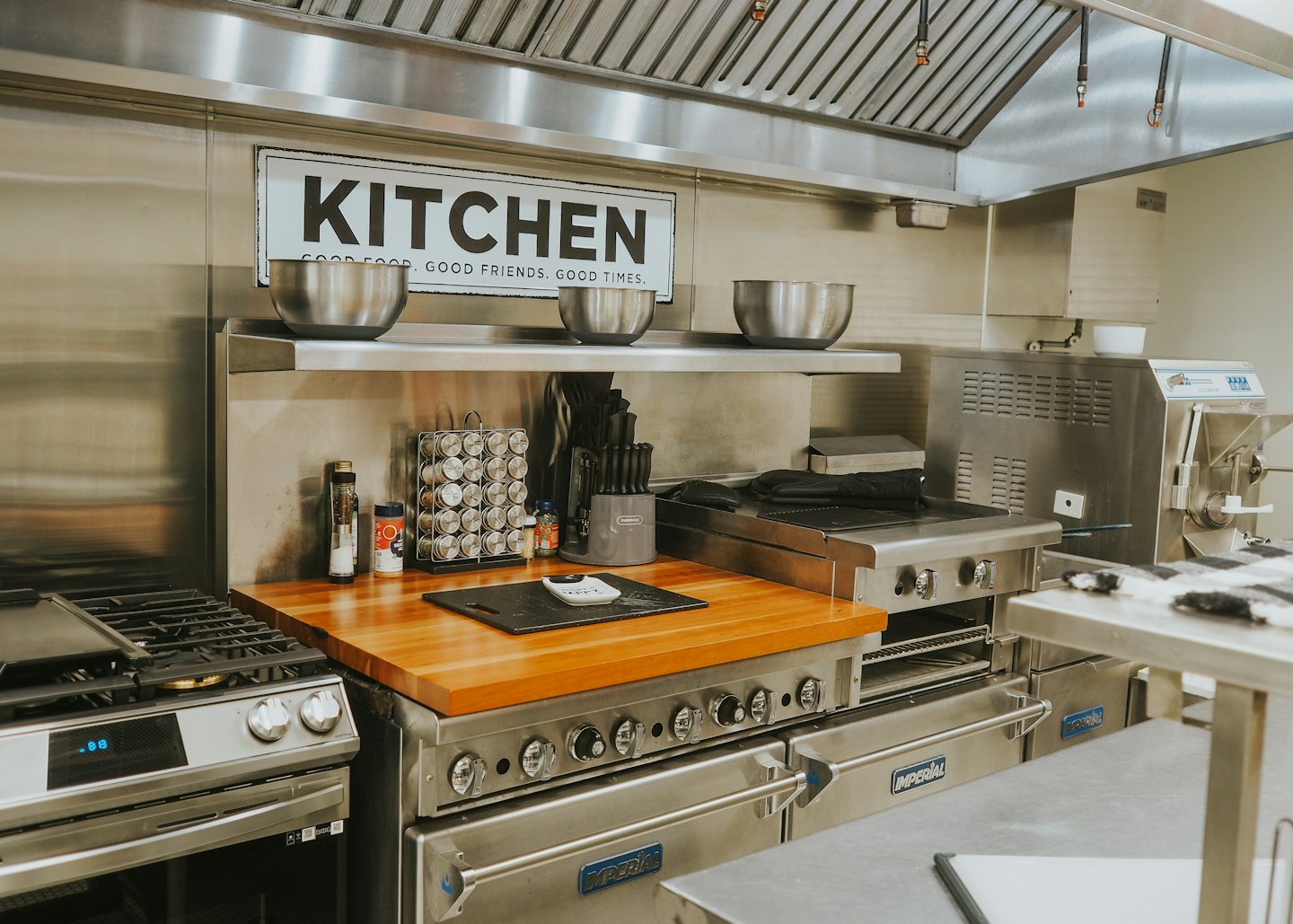 Professional kitchen appliances and a wooden countertop with cooking tools.